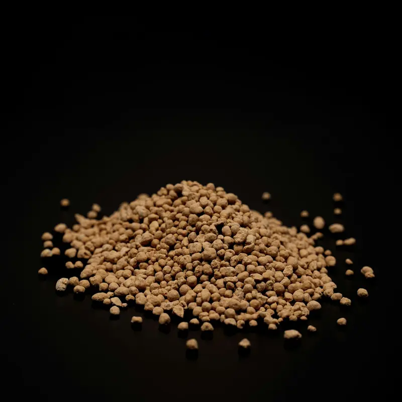 Pile of light brown fertilizer crystals on black